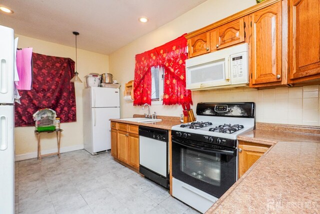 kitchen with light countertops, white appliances, brown cabinetry, and a sink