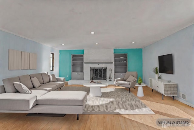 living room featuring a brick fireplace and light hardwood / wood-style flooring