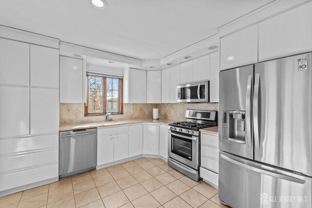 kitchen featuring white cabinetry, sink, tasteful backsplash, and appliances with stainless steel finishes