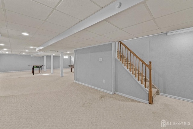 basement with carpet flooring and a paneled ceiling