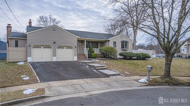 single story home featuring a garage, a porch, and a front yard