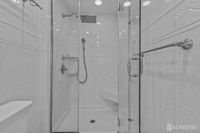 bathroom featuring walk in shower and toilet