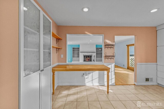 kitchen featuring light tile patterned floors and a fireplace