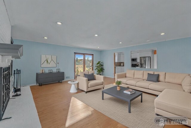 living room featuring crown molding and light hardwood / wood-style floors