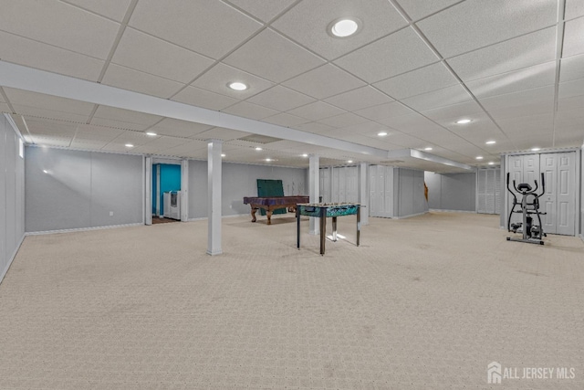 basement with a paneled ceiling and light carpet