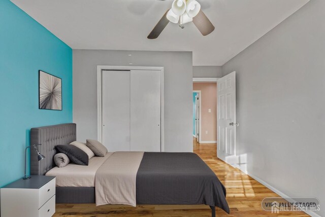 bedroom with ceiling fan, light hardwood / wood-style floors, and a closet