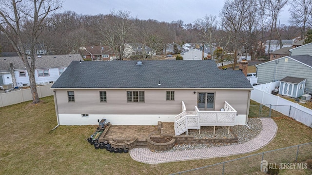 rear view of house featuring a wooden deck and a yard