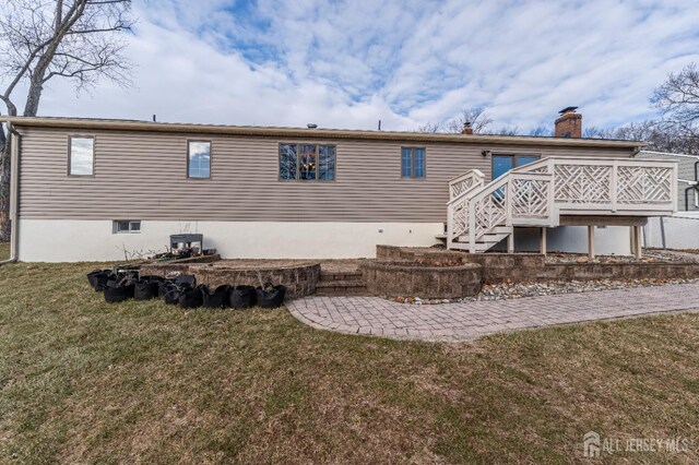 back of house with a wooden deck and a yard