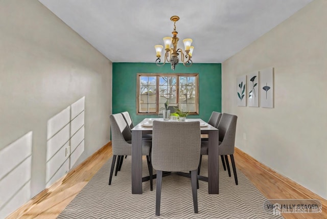 dining space featuring a notable chandelier and light hardwood / wood-style floors