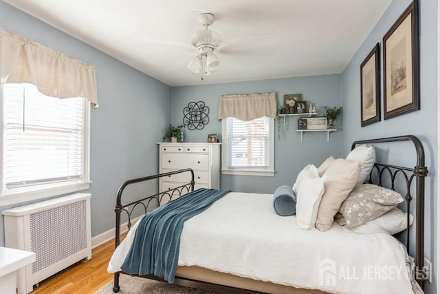 bedroom featuring ceiling fan, hardwood / wood-style flooring, and radiator heating unit