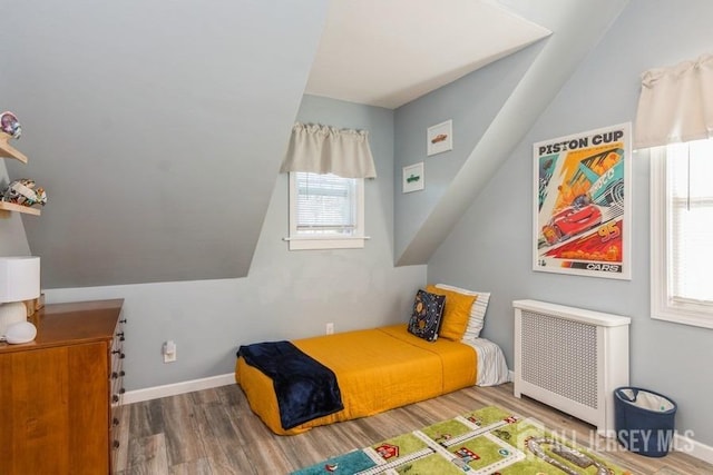 bedroom with hardwood / wood-style flooring and radiator