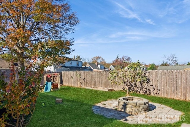 view of yard featuring a playground, a fire pit, and a patio