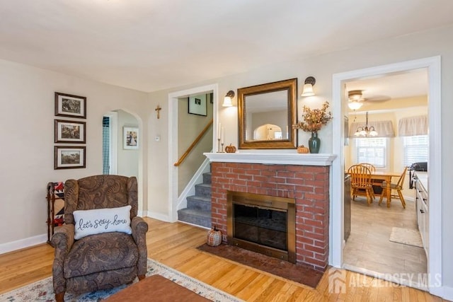 living area with light wood-type flooring and a brick fireplace