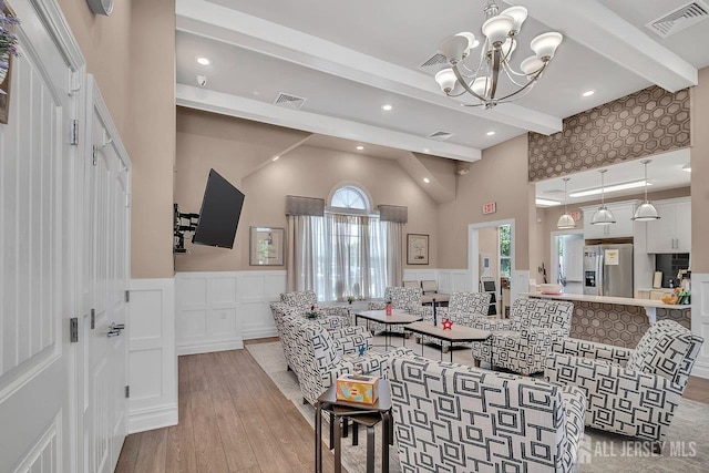 30 Grabowski Dr, Sayreville, NJ 08859 - dining area with beam ceiling, light wood finished floors, wainscoting, a decorative wall, and a chandelier
