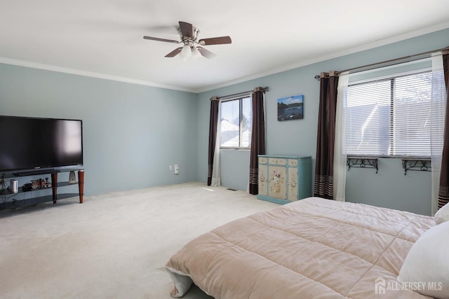 carpeted bedroom with ornamental molding and ceiling fan