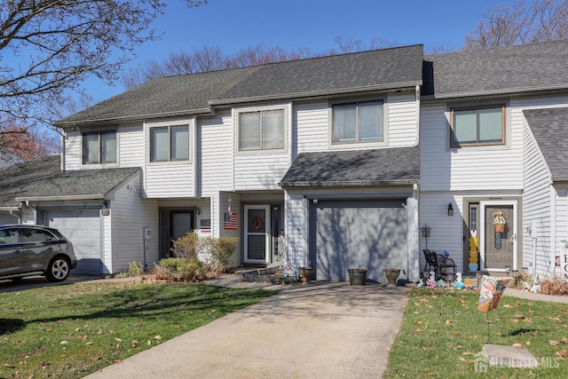 townhome / multi-family property featuring concrete driveway, an attached garage, a front lawn, and roof with shingles