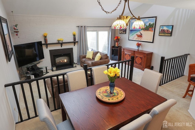 dining space featuring light colored carpet and a glass covered fireplace