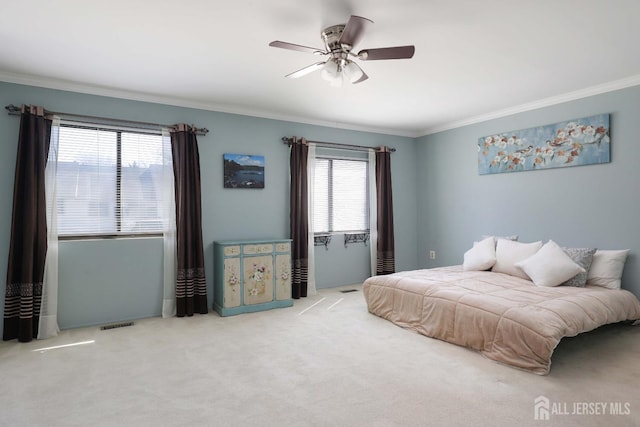 carpeted bedroom with ornamental molding and a ceiling fan