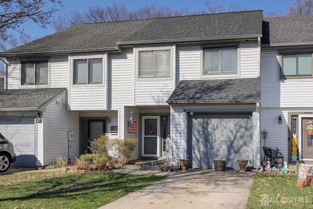view of property featuring an attached garage, driveway, and roof with shingles