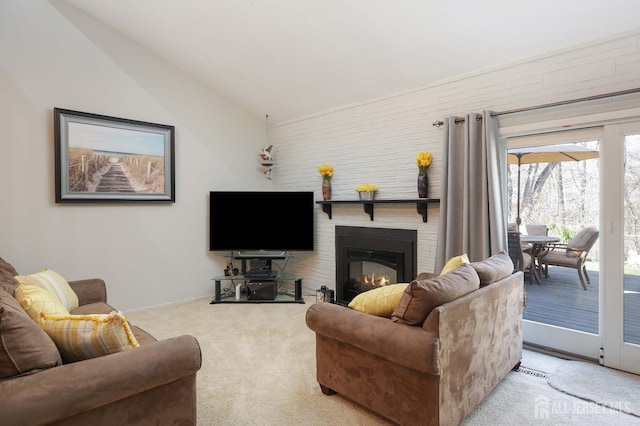 carpeted living area with a large fireplace, baseboards, and lofted ceiling