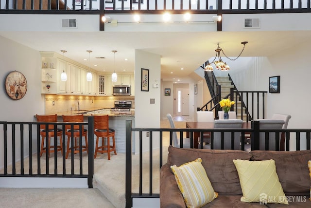 carpeted living room with stairs, recessed lighting, a sink, and a chandelier
