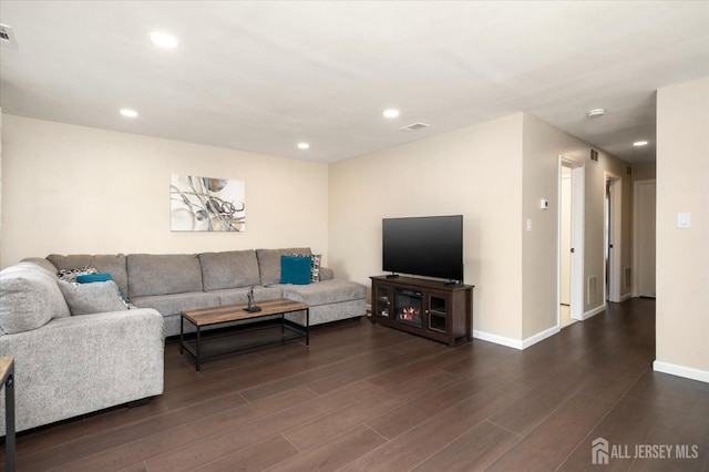 living area with dark wood finished floors, recessed lighting, visible vents, and baseboards