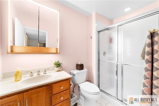full bathroom featuring a shower stall, toilet, vanity, and tile patterned floors