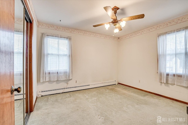 carpeted spare room with ceiling fan and a baseboard radiator