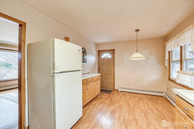 kitchen with decorative light fixtures, light hardwood / wood-style flooring, a healthy amount of sunlight, and white refrigerator