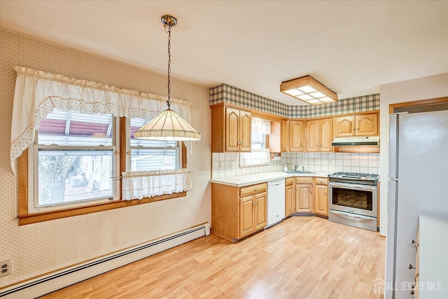 kitchen featuring pendant lighting, sink, white appliances, baseboard heating, and light wood-type flooring