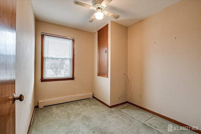 carpeted spare room with ceiling fan and a baseboard heating unit