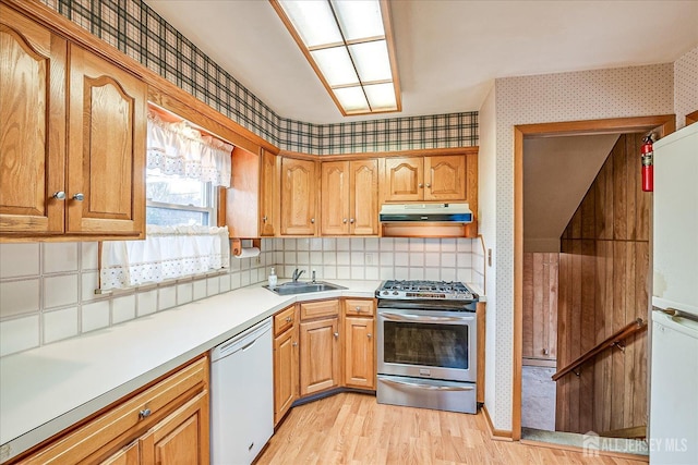 kitchen with sink, white appliances, decorative backsplash, and light wood-type flooring