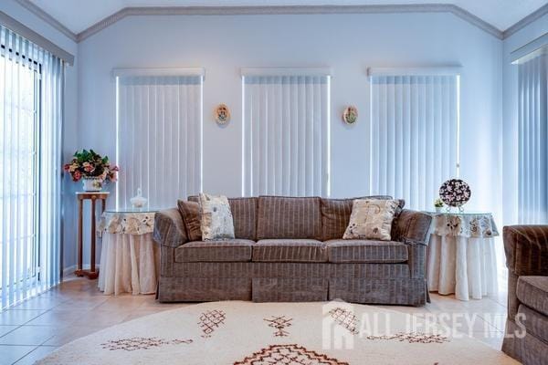 tiled living room with crown molding and lofted ceiling