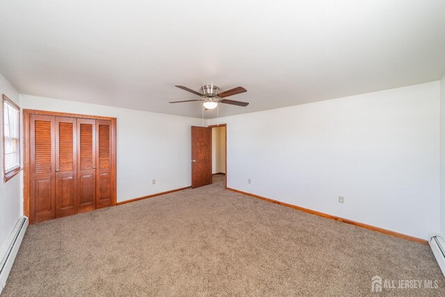 unfurnished bedroom featuring a closet, ceiling fan, carpet flooring, and a baseboard radiator