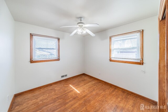 unfurnished room with hardwood / wood-style floors and ceiling fan