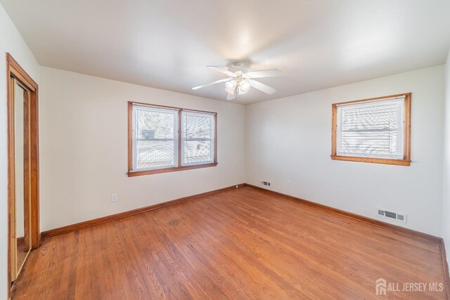 empty room with light wood-type flooring, a closet, and ceiling fan