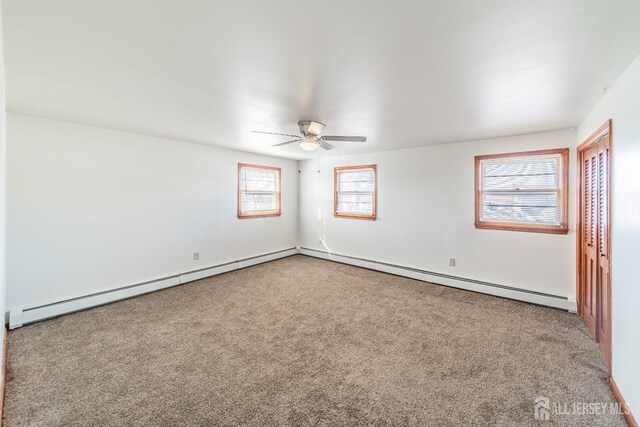 carpeted empty room with a baseboard radiator and ceiling fan