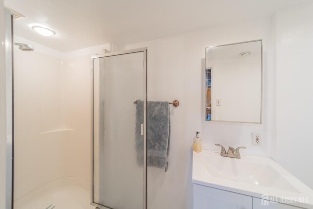 bathroom with vanity and a shower with shower door