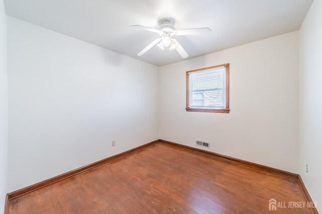 spare room with hardwood / wood-style flooring and ceiling fan