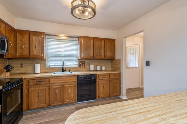 7 Sherbone Pl, Sayreville, NJ 08859 - kitchen with black appliances, a sink, light countertops, and brown cabinetry