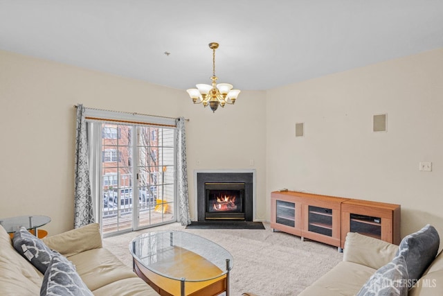 living room with a glass covered fireplace, carpet flooring, and an inviting chandelier