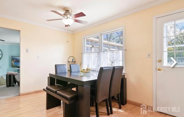 dining room with ceiling fan, ornamental molding, light wood-type flooring, and baseboards