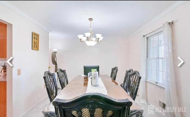dining area with a chandelier, ornamental molding, and baseboards