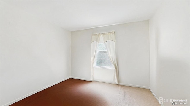 spare room with baseboards