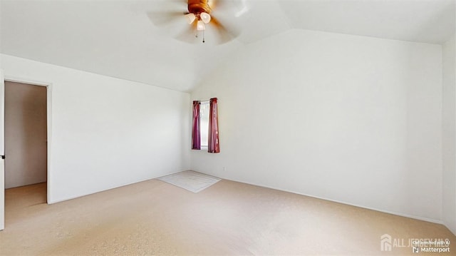 spare room with lofted ceiling, carpet, and a ceiling fan
