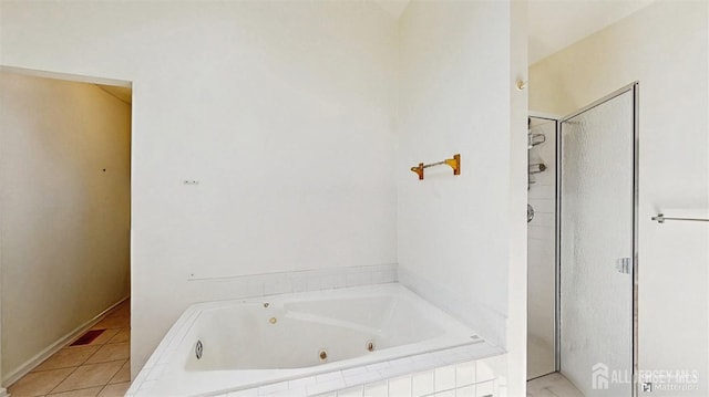 bathroom featuring tile patterned floors, a tub with jets, and a walk in shower