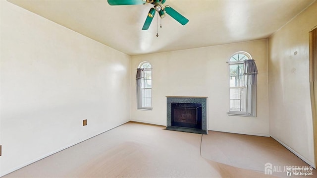 unfurnished living room featuring a fireplace with flush hearth and a ceiling fan