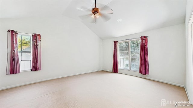 spare room with vaulted ceiling, a ceiling fan, and baseboards
