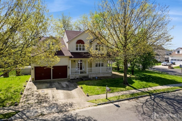 traditional-style house with fence, a front lawn, driveway, covered porch, and a garage