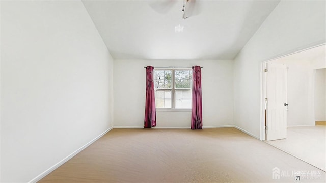 spare room featuring baseboards, a ceiling fan, carpet flooring, and lofted ceiling